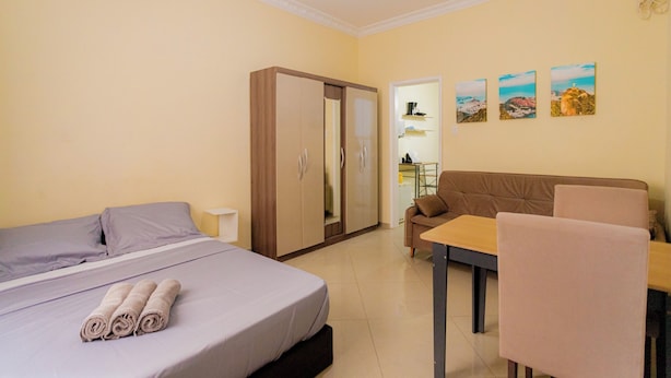 Een hotelkamer met een bed, een kledingkast, een bank, een tafel en een stoel.