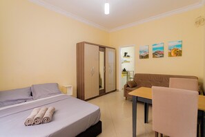 Ein Hotelzimmer mit einem Bett, einem Kleiderschrank, einer Couch, einem Tisch und einem Stuhl.
