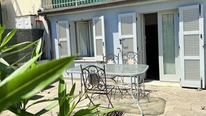 Un bâtiment doté d’un balcon, d’une table avec des chaises et d’une porte.
