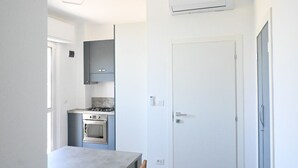 Une cuisine compacte équipée d’une cuisinière à gaz, d’un four et de placards intégrés.