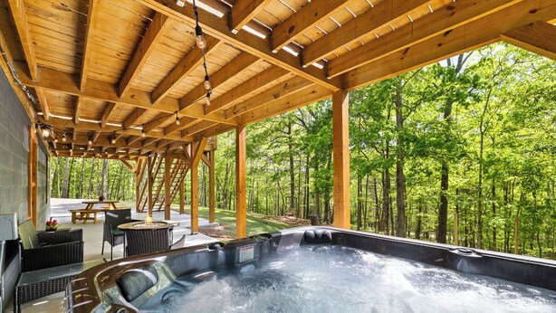 A hot tub under a wooden pergola with a forest view. - Blue Deer Mountain - Hot Tub | Fire Pit | Tree House Fun (Blue Ridge)