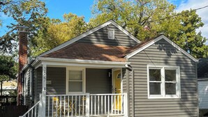 A two-story house with a front porch, a chimney, and a garage.
