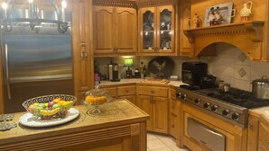 A kitchen with wooden cabinets, a refrigerator, a stove, and a microwave.