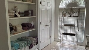 A room with a white wardrobe, a door, and a window with blinds.