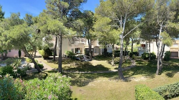 Un quartier résidentiel composé de plusieurs maisons, d’arbres et d’une pelouse bien entretenue.