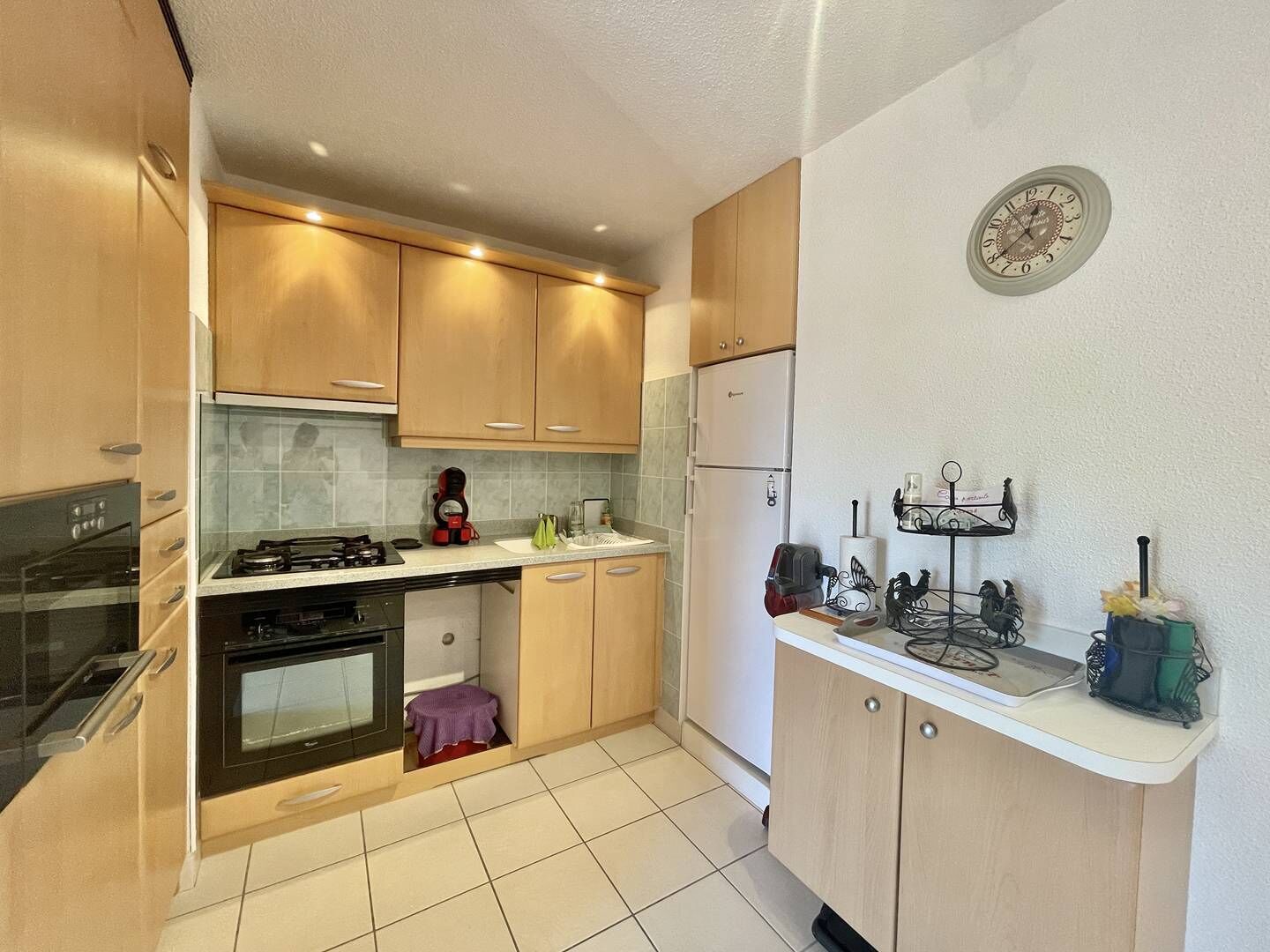Une cuisine de taille réduite équipée d’une cuisinière à gaz, d’un four et d’un réfrigérateur.
