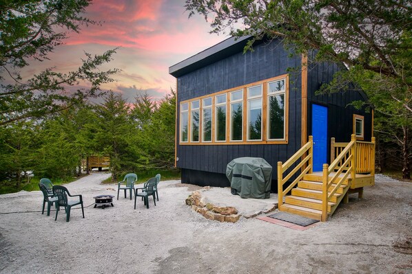 A cabin with a deck, outdoor seating, and a barbecue grill. - Modern Cabin. Communal Sleeping - 2 Queen Beds + Full Trundle (Ashland)