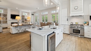 A spacious kitchen with white cabinetry, a central island, and a large stove. - Pet Friendly, Lake District Watercolor, Tesla Charger (Santa Rosa Beach)