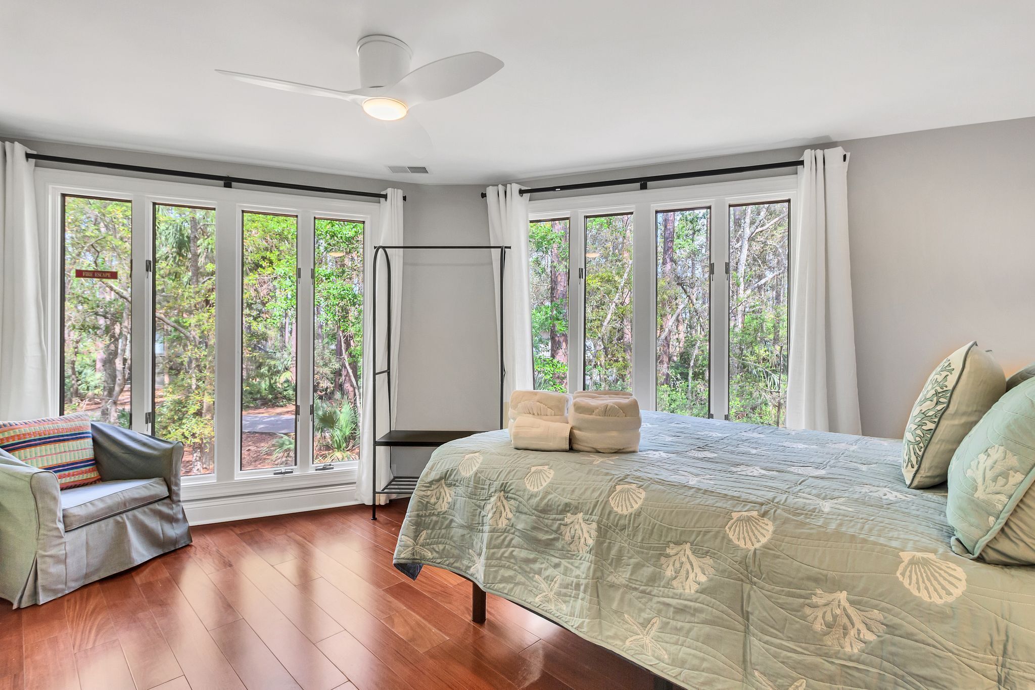 A bedroom with a bed, a sofa, and a ceiling fan.