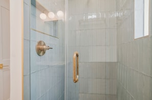 A shower area with a glass door, a metallic handle, and a wall-mounted mirror. - 1605 Port Villas at The Sea Pines Resort (Hilton Head Island)