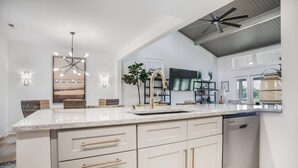 A modern kitchen with a central island, white cabinetry, and a ceiling fan. - 6954 Fairway One at The Sea Pines Resort (Hilton Head Island)
