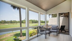 A covered outdoor area with large windows, a wooden deck, and a view of a golf course. - 6954 Fairway One at The Sea Pines Resort (Hilton Head Island)