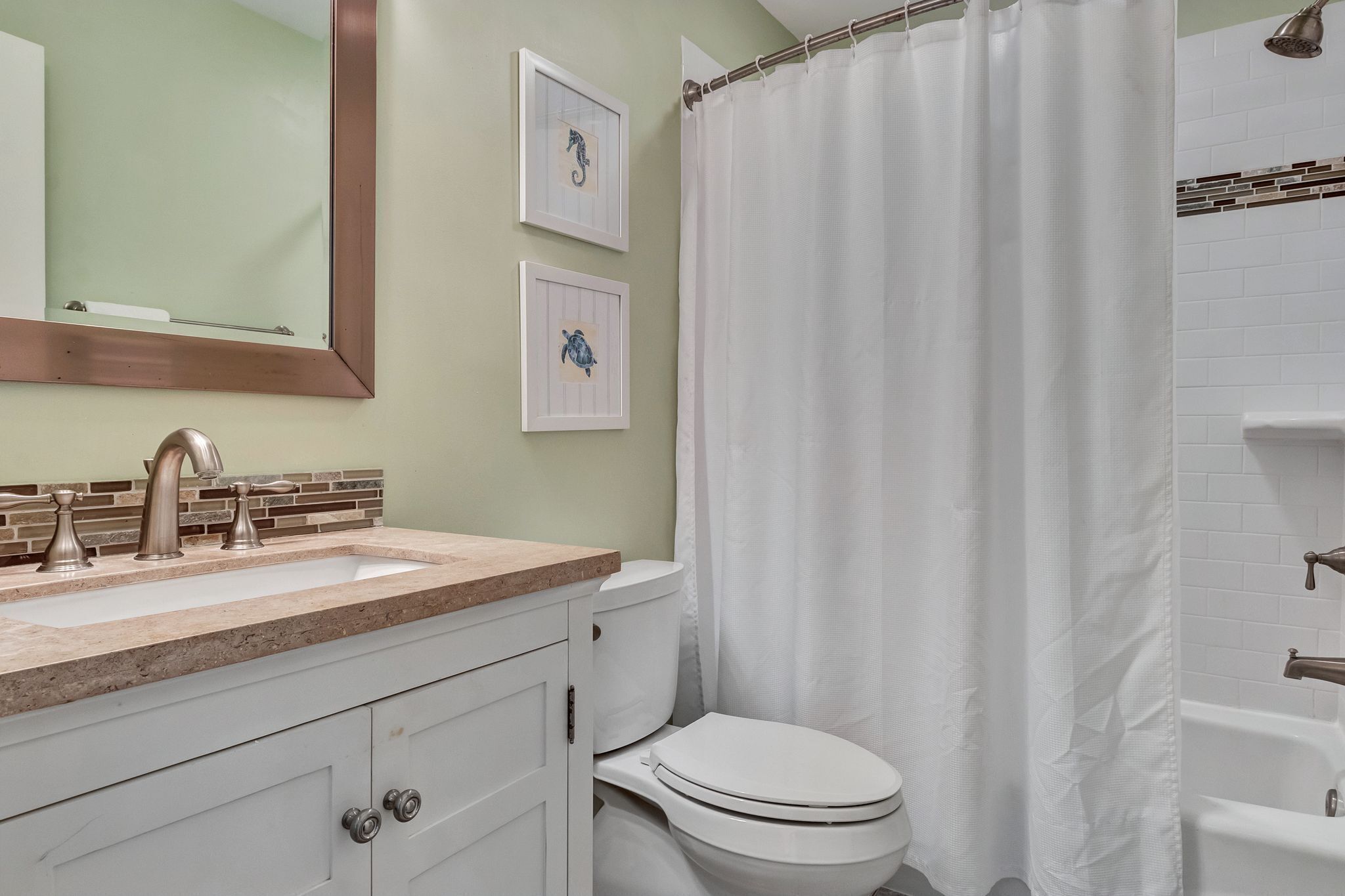Un baño con lavamanos, inodoro y bañera.