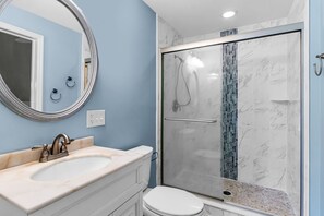 A bathroom with a marble sink, a toilet, and a glass-enclosed shower with a marble wall. - 67 Forest Drive at The Sea Pines Resort (Hilton Head Island)