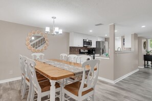 Una cocina moderna con armarios blancos, microondas y refrigerador.
