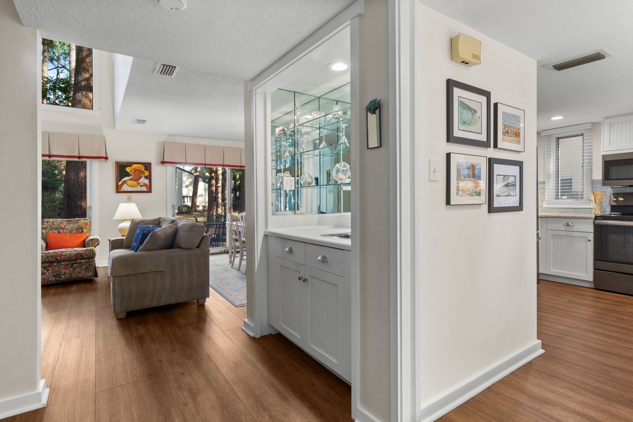 A modern kitchen with white cabinets, a built-in oven, and a microwave.