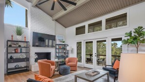 A spacious living room with a fireplace, comfortable seating, and a large TV. - 6966 Fairway One at The Sea Pines Resort (Hilton Head Island)