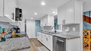 A modern kitchen with white cabinets, granite countertops, and stainless steel appliances. - 248 Stoney Creek Villa at The Sea Pines Resort (Hilton Head Island)