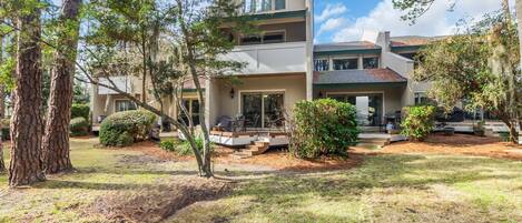 A two-story house with a front porch, a covered outdoor seating area, and a well-maintained lawn.