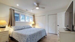 A bedroom with a bed, nightstands, a ceiling fan, a TV, and a wardrobe. - 97 Fairway Lane at The Sea Pines Resort (Hilton Head Island)