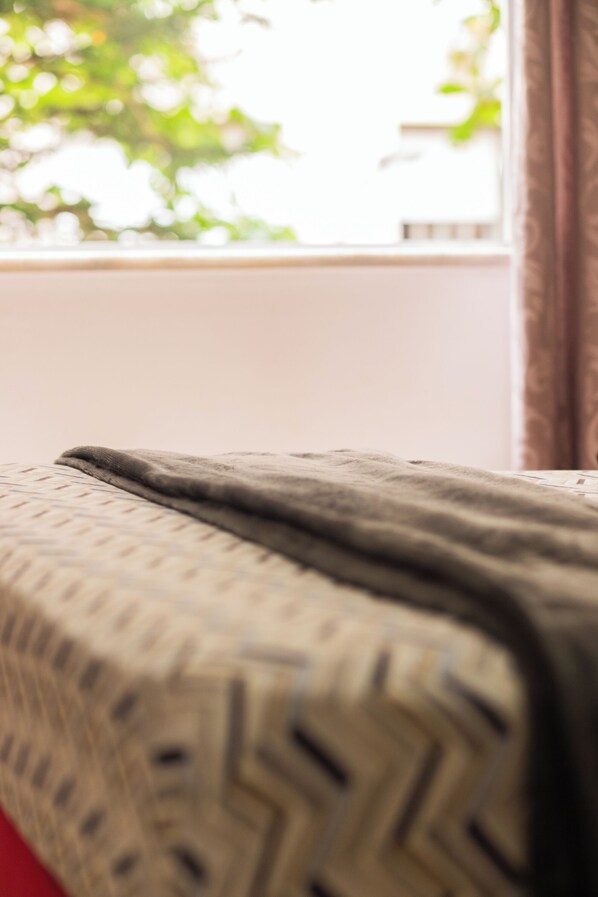 Un gros plan d’un tissu à motifs, probablement une couvre-lit ou une couverture, orné d’un motif géométrique.