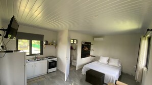 A compact, well-lit room with a kitchenette, a bed, and a dining area. - Tahiti - Bungalow Toah Toru (Taiarapu-Ouest)
