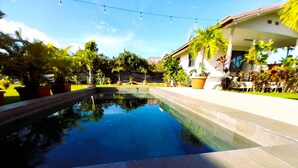 A swimming pool with a clear view of the surrounding greenery and a building in the background. - Tahiti - Bungalow Toah Toru (Taiarapu-Ouest)