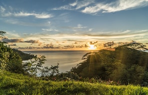 A coastal landscape with a sunset over the water, surrounded by lush greenery. - Raiatea - Studio Tumaraa (Raiatea)