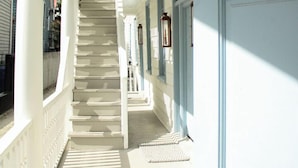 Una escalera de madera blanca que conduce a una puerta con picaporte.
