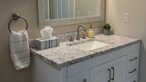A bathroom with a white vanity, a large mirror, and a sink. - Guest house in Hurricane Mills (Hurricane Mills)