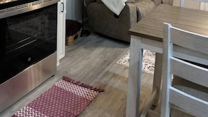 A compact living space with a kitchenette, a sofa, a dining table, and a floor lamp. - Guest house in Hurricane Mills (Hurricane Mills)
