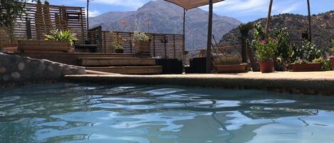 Una piscina al aire libre de temporada, sillones reclinables de piscina