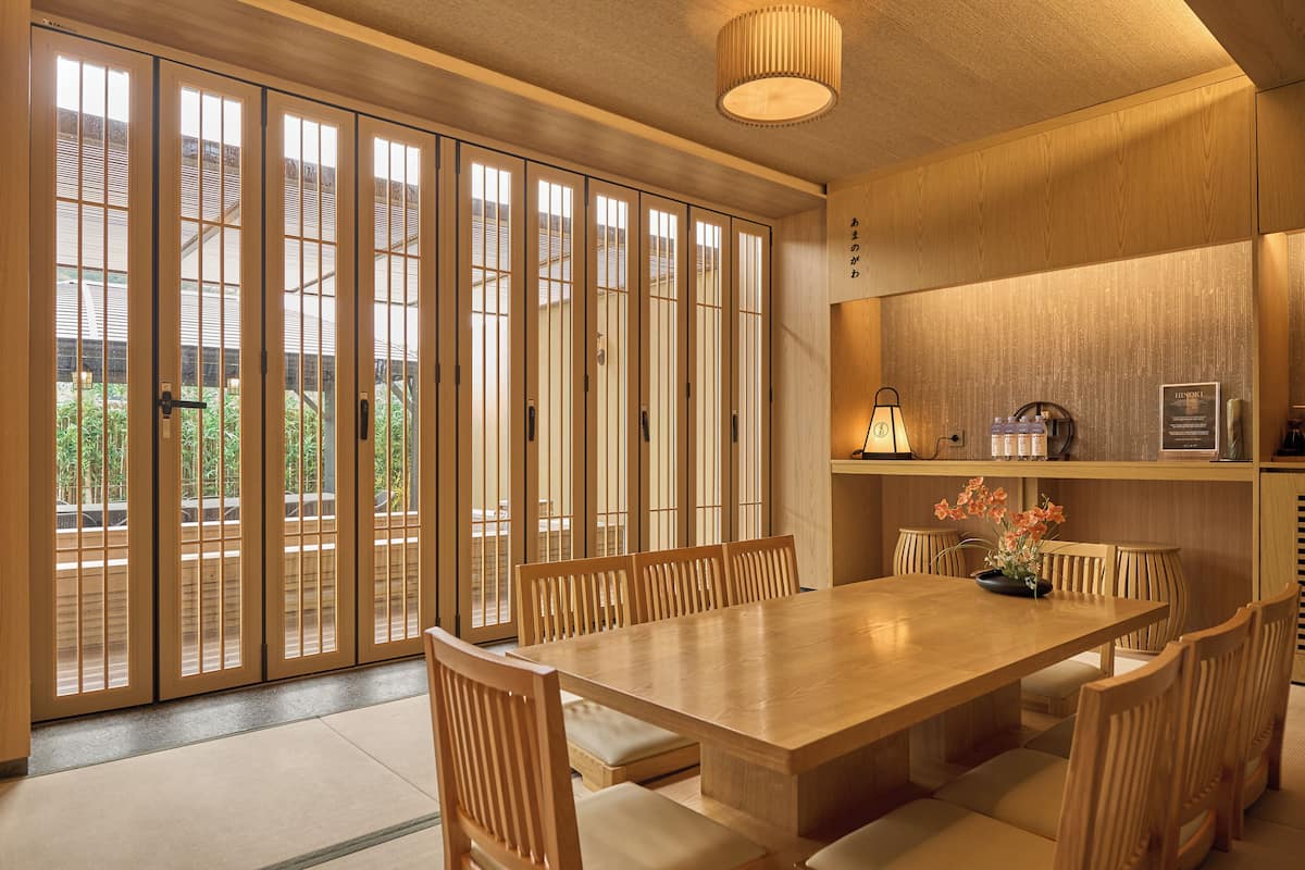 A traditional Japanese-style room with sliding doors, a wooden dining table, and chairs.
