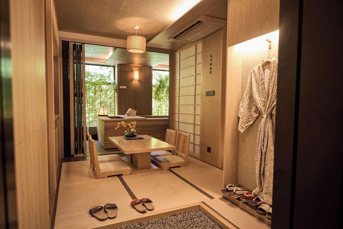 A traditional Japanese-style room with tatami flooring, a low wooden table, and a seating arrangement.