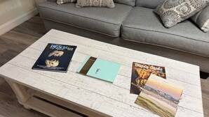 Un tavolino in legno con tre guide turistiche e un quaderno.