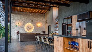 Eine moderne Küche mit Steinwand, Holzschränken und einem integriertem Kühlschrank.
