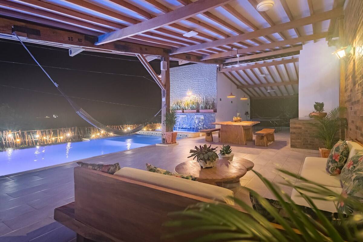 Ein Poolbereich im Freien mit Holzmöbeln und Blumentöpfen.