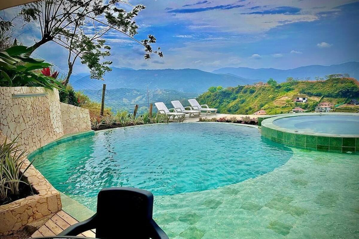 Ein Pool mit Blick auf Berge, Liegestühle und ein Tisch.