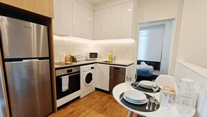 A modern kitchen with stainless steel appliances, a dishwasher, and a compact oven.