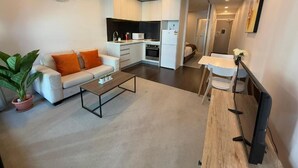 Una sala de estar moderna con un sofá, una mesa de centro y una zona de comedor con una mesa y sillas.