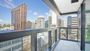 Un edificio alto con balcón que da a una vista panorámica de la ciudad.