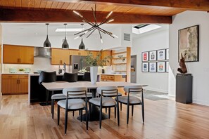 A modern kitchen with wooden cabinets, a central island, and pendant lighting. - Stunning Mid-Century Home with Scenic Views! (Santa Barbara)