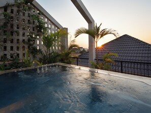 A swimming pool with a view of a building and a sunset. - Private 2BR Villa Rooftop Pool, Full Kitchenette, Big Living Room, Wifi (Krong Siem Reap)