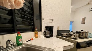 A kitchen with a stainless steel sink, a coffee maker, and a stove. - Charming 2-bedroom house with Pool in gorgeous Puerto Escondido (Brisas de Zicatela)