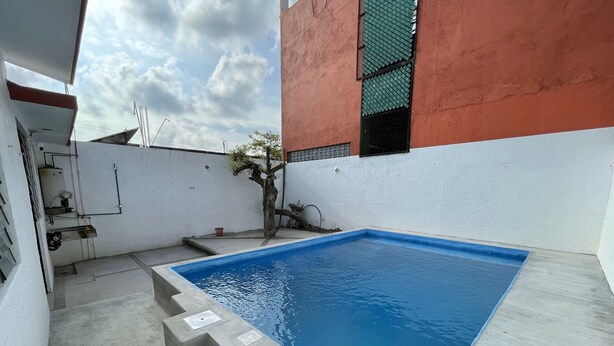 A rectangular swimming pool with a blue interior, surrounded by a concrete deck. - Charming 2-bedroom house with Pool in gorgeous Puerto Escondido (Brisas de Zicatela)