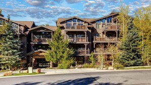 A multi-story building with balconies, a covered entrance, and a sign that reads 'BLACK BEAR LODGE.' - Abode at Black Bear #207, hot tub, pool & gym, Deer Valley (Park City)
