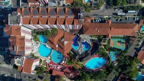 An aerial view of a resort with multiple swimming pools, a tennis court, and a variety of buildings with red-tiled roofs. - Hot Springs Hotel (Caldas Novas)