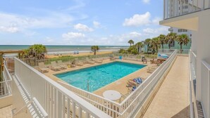A rooftop pool with a view of the beach and ocean.