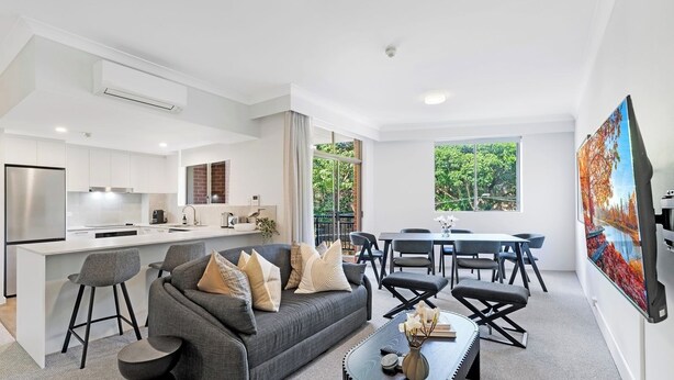 A modern apartment with a kitchen, dining area, and living room. - KozyGuru | Camperdown | Cozy 2-Bed Apt + Parking (Camperdown)
