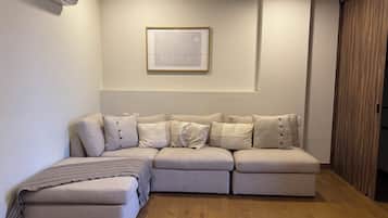 Departamento Deluxe, vista a la ciudad | Área de sala de estar | Smart TV de 75 pulgadas con canales digitales